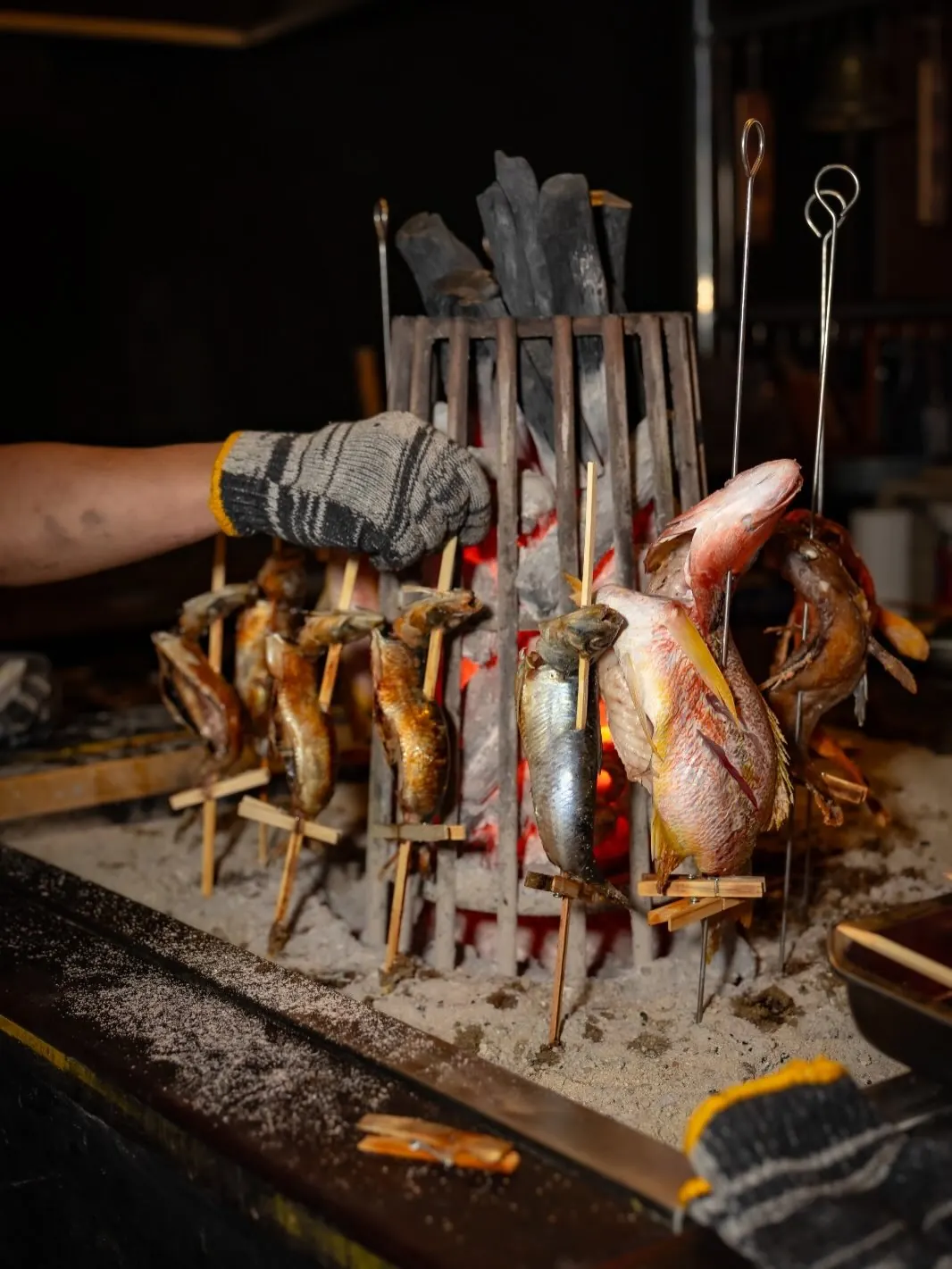 Skewered fish around the pit